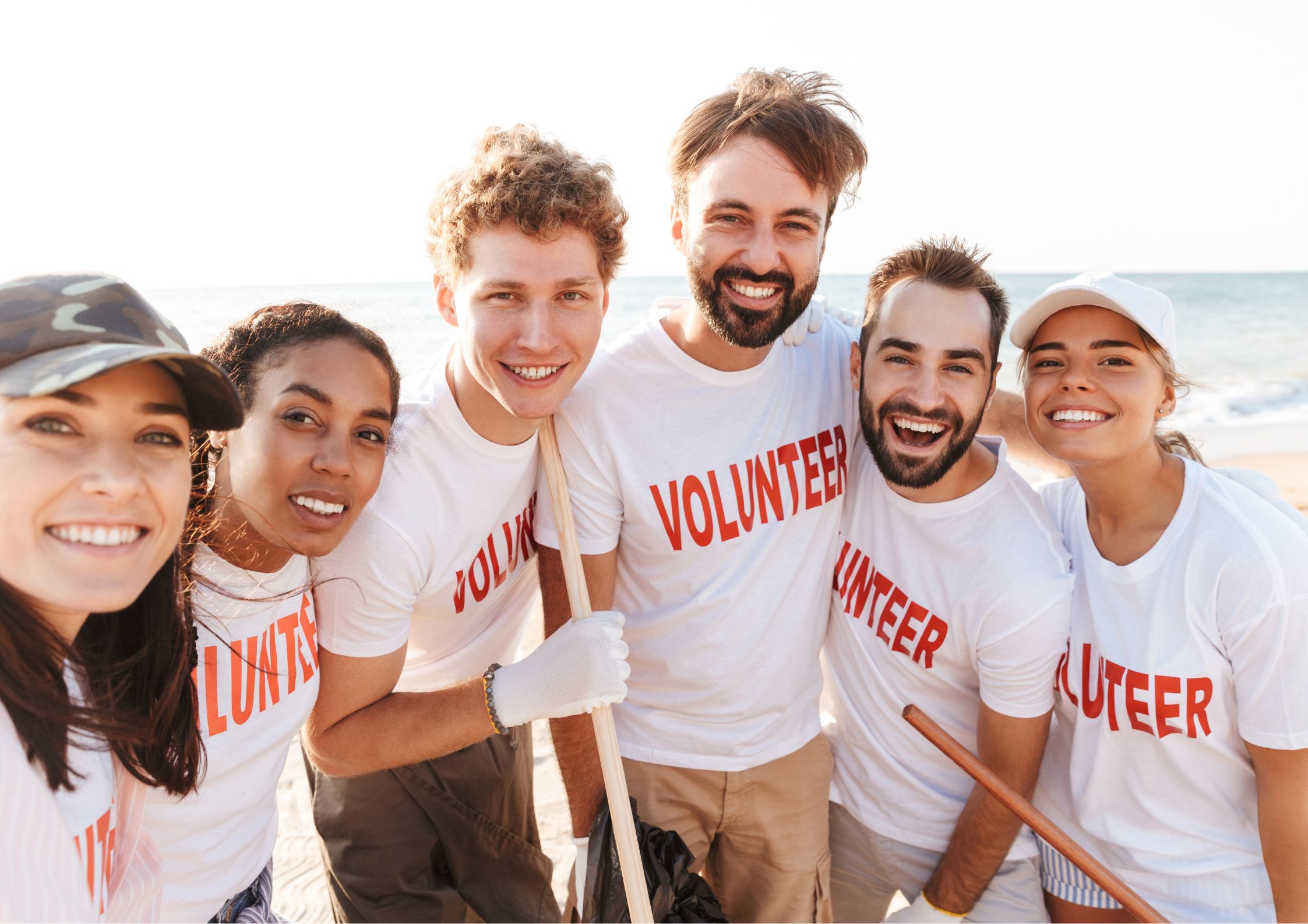 Image of a group of volunteers picking up trash at the beach for a nonprofit organization